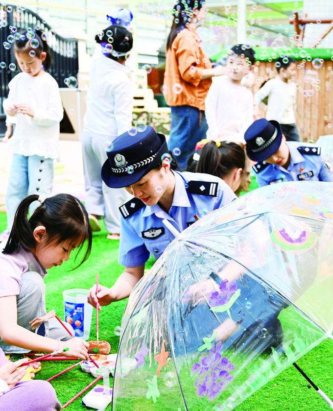 民警和幼儿园的小朋友共绘安全知识伞